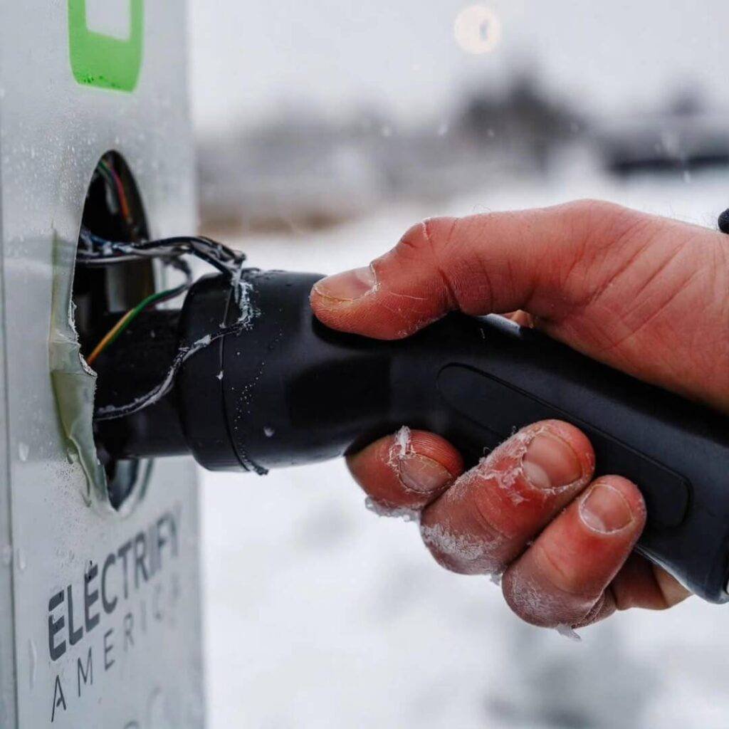 Frostbitten fingers fumbling J1772 plug at broken Electrify America station.