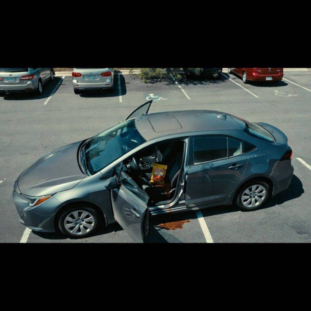 Drone view: Corolla in handicapped spot, door open, Skyline chili spilling.