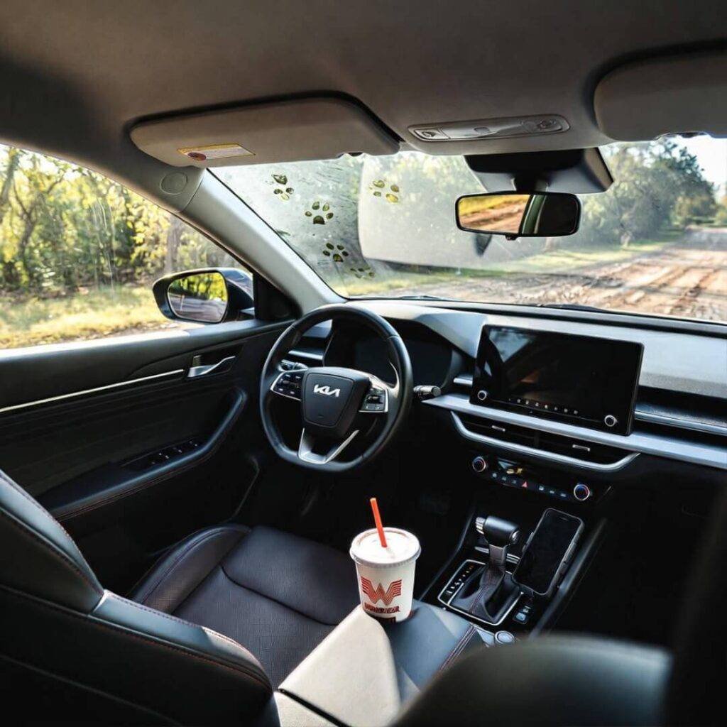 Kia Seltos interior: muddy road ahead, dog paw prints, Whataburger cup.