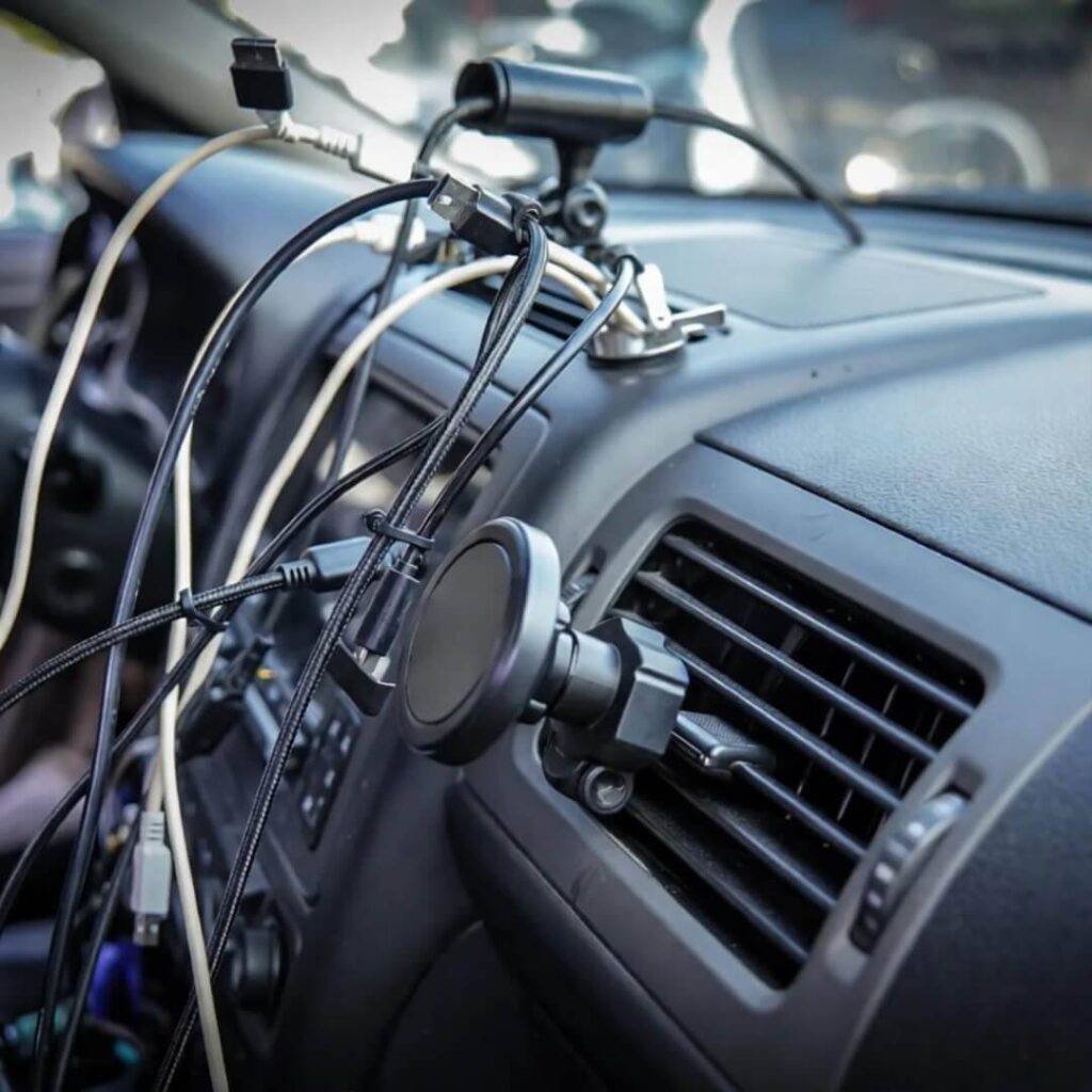 Zip-tied USB cables tangle under dash; $6 magnetic mount bends vent.