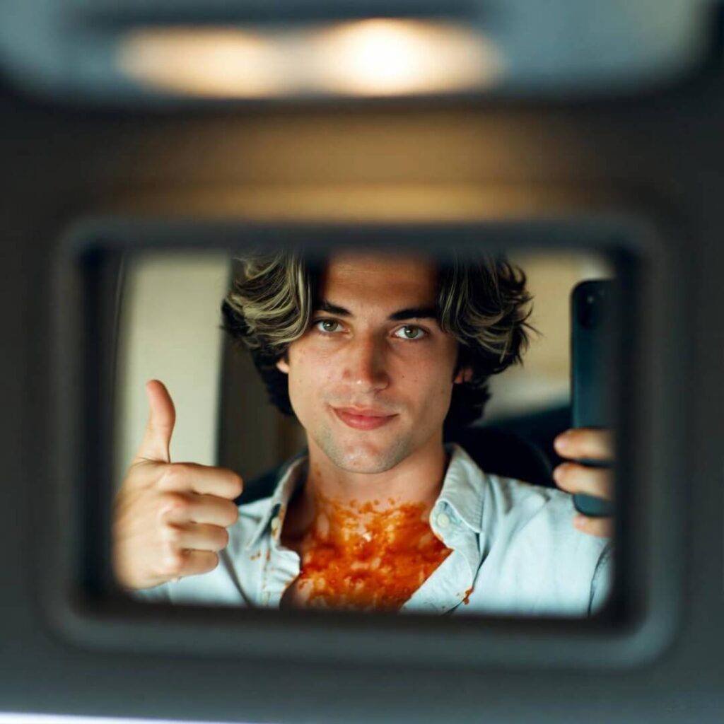 Blurry rearview selfie: chili-stained shirt, weary thumbs-up surrender.