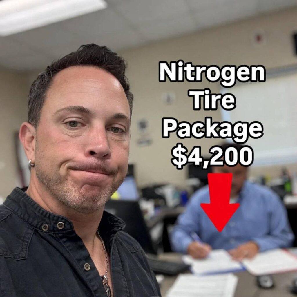 Smirking finance guy as I sign away $4,200 nitrogen tire package. Blurry iPhone shot.