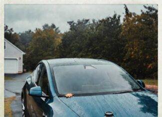 Electric Cars: Myths vs. Reality in 2025 Rain-soaked teal Tesla Model Y with coffee cup, autumn leaf, and skeptical reflection in puddle.