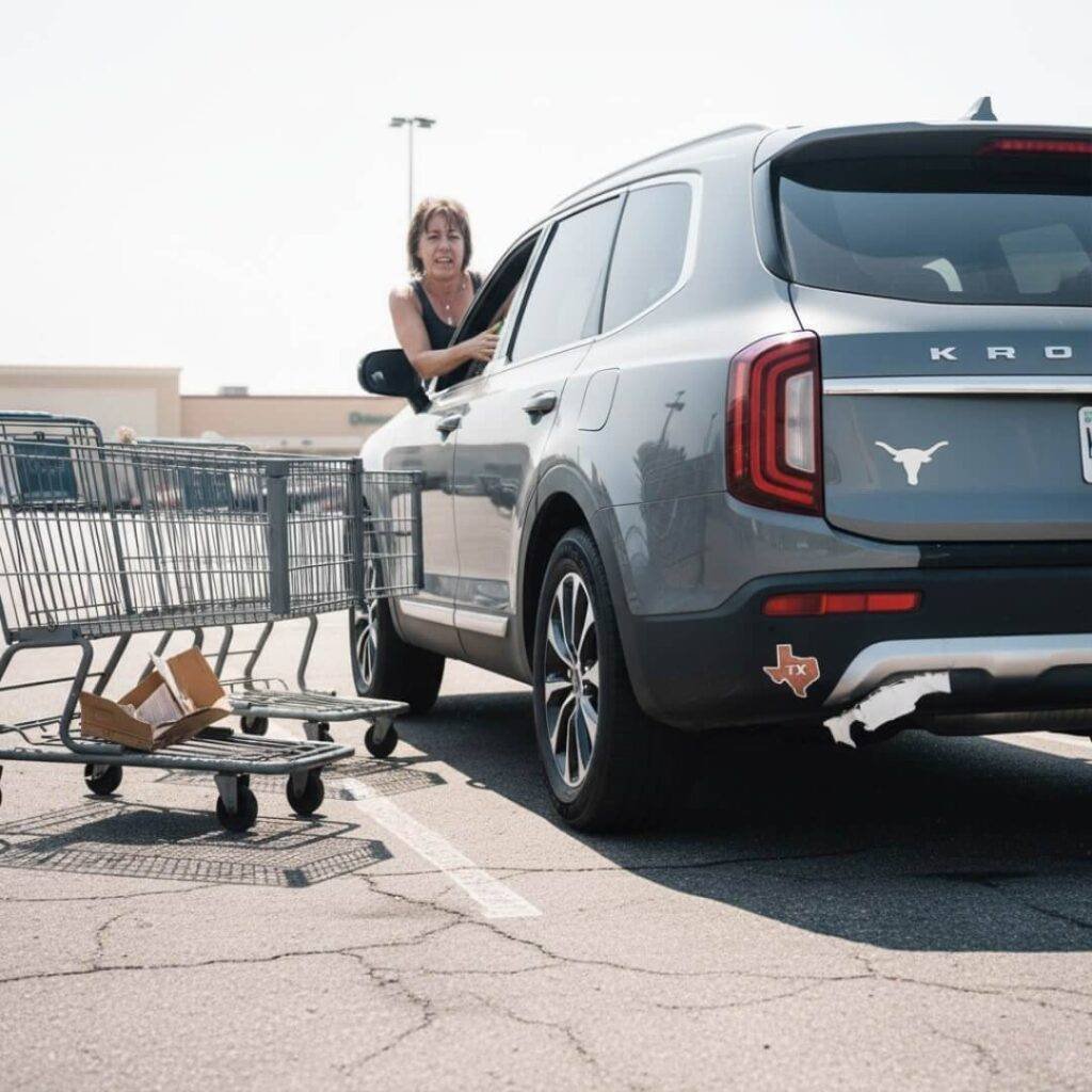 Sweating man parallel parking a large SUV.