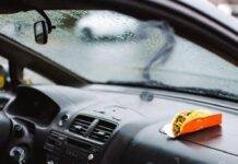 Best Coverage for First-Time Car Owners Rainy car interior with taco wrapper, insurance card, and smoky question marks.