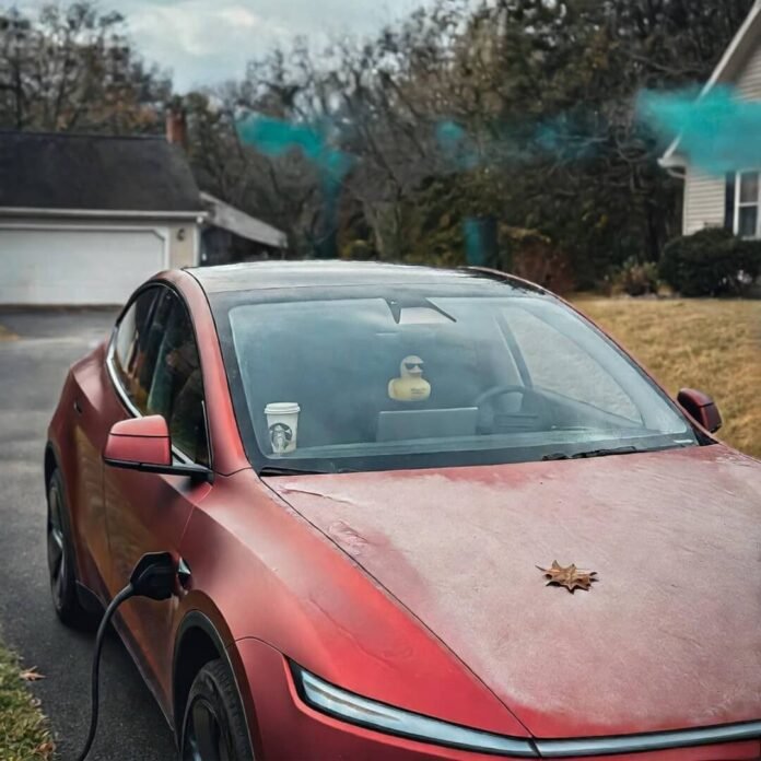Red Tesla Model Y with frost, charging at dawn, duck on mirror. Red Tesla Model Y with frost, charging at dawn, duck on mirror.
