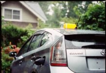 Are Hybrid Cars Worth the Extra Cost? Let’s Break It Down Rainy Seattle driveway: crooked Prius charging, forgotten Starbucks cup, peeling "I ♥ Gas" sticker, lone dandelion.