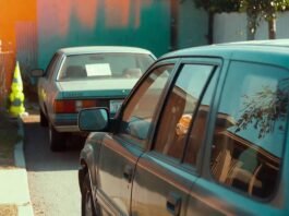 Is Long-Term Car Leasing Better Than Buying? Dented teal SUV parked crookedly, fast-food bag inside, "For Sale" sedan behind.