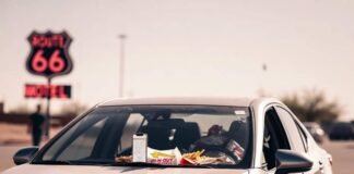 How to Save Big on Long-Term Car Rentals Beat-up Toyota Camry with In-N-Out trash, cracked phone, and flickering Route 66 sign.