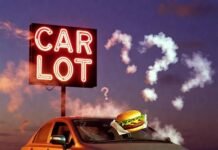 Buying a Used Car? Check These 10 Reliability Ratings First Dusty 2009 Honda Civic under flickering CAR LOT neon, burger on hood, smoky question marks at dusk.