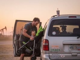3-Row SUVs Ranked: Which One Is Best for You? Dad wrestling stroller into minivan at sunset.