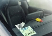 EV Tax Credits Explained: How Much Can You Save? Crooked IRS Form 8936 sticker and "7K credit???" Starbucks receipt on dusty Tesla windshield.