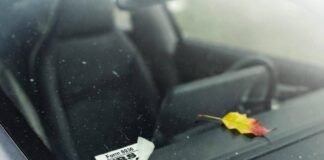 EV Tax Credits Explained: How Much Can You Save? Crooked IRS Form 8936 sticker and "7K credit???" Starbucks receipt on dusty Tesla windshield.