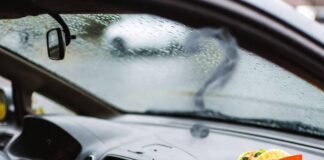 Best Coverage for First-Time Car Owners Rainy car interior with taco wrapper, insurance card, and smoky question marks.